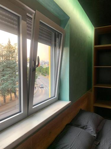 a window in a room with a bed next to it at Something Different in Nikšić