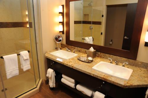 a hotel bathroom with two sinks and a shower at Twin Arrows Navajo Casino Resort in Flagstaff