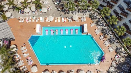 una vista aérea de una piscina con sillas y sombrillas en Servatur Don Miguel - Adults Only en Playa del Inglés