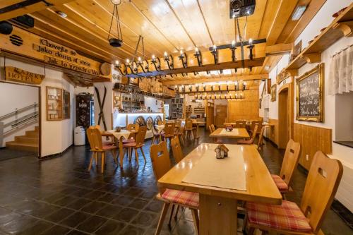 a restaurant with wooden tables and chairs in a room at Horsky hotel Rajska bouda in Malenovice