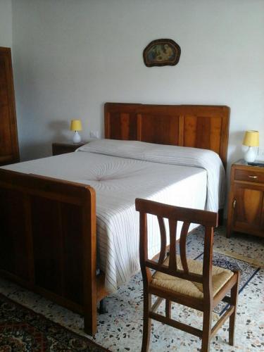 a bedroom with a large bed and a chair at Il Mandorlo in Ficulle