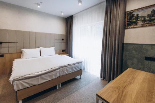 a bedroom with a large bed and a window at Hotel Vedmezhyi Dvir in Bukovel