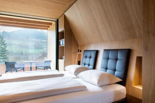 dwa łóżka w pokoju z dużym oknem w obiekcie Der Reschenhof w mieście Mils bei Hall