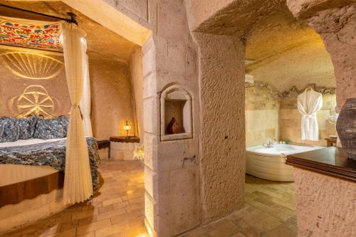 a bedroom with a bed and a tub in a room at Adora Cave Suites - in Göreme