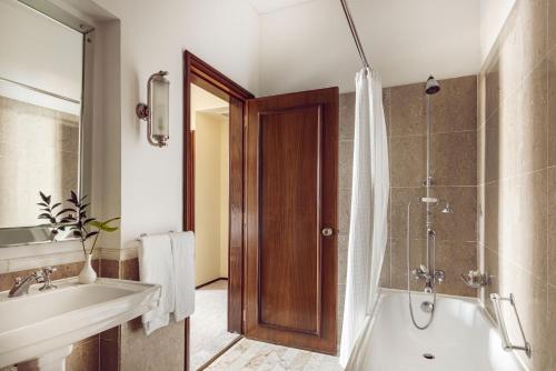 a bathroom with a tub and a sink and a shower at Reid's Palace, A Belmond Hotel, Madeira in Funchal