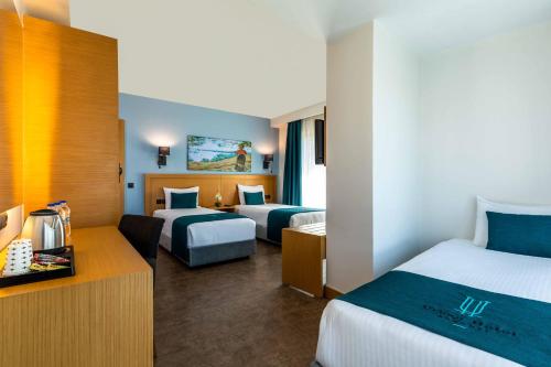a hotel room with two beds and a desk at Urban Hotel Bomonti in Istanbul