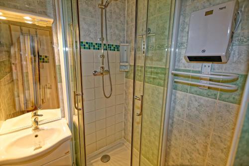 ein Bad mit einer Dusche und einem Waschbecken in der Unterkunft le burel la triade 4 personnes in Lanslevillard