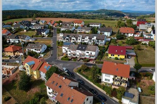 una vista aérea de una pequeña ciudad con casas en Fränkische Rhön Wohnung mit Bergblick ツ, en Bad Kissingen
