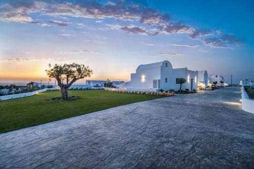 a villa with a view of the ocean at dusk at Kyklos Villas - luxury villas with private pool in Karterados