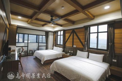 2 camas en una habitación con paredes y ventanas de madera en Gaodiyuan Tea B&B 高帝園茶業民宿 en Meishan