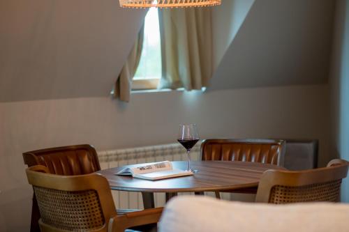 a table with a glass of wine and a book at Ski Hotel in Žabljak