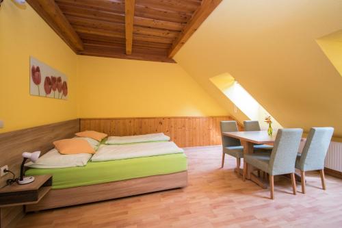 a bedroom with a bed and a table and chairs at Penzion Sidorovo in Ružomberok