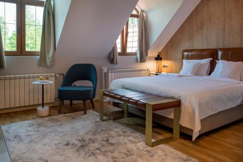 a bedroom with a bed and a chair and windows at Ski Hotel in Žabljak