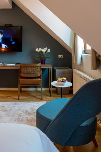 a living room with a blue chair and a tv at Ski Hotel in Žabljak