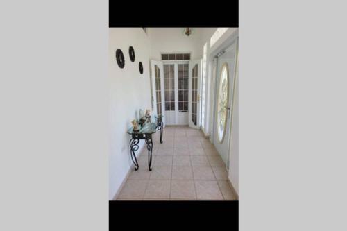 um corredor com paredes brancas e uma mesa num quarto em My dulce hogar em Isabela
