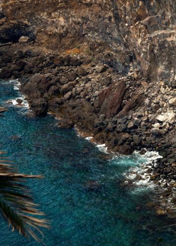 a view of a rocky shore with blue water at Reid's Palace, A Belmond Hotel, Madeira in Funchal