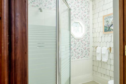 a shower with a glass door in a bathroom at Engadine Inn and Cabins in Candler