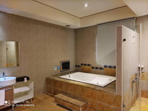 ein Badezimmer mit Badewanne und Waschbecken in der Unterkunft Blue Sky Motel in Guishan