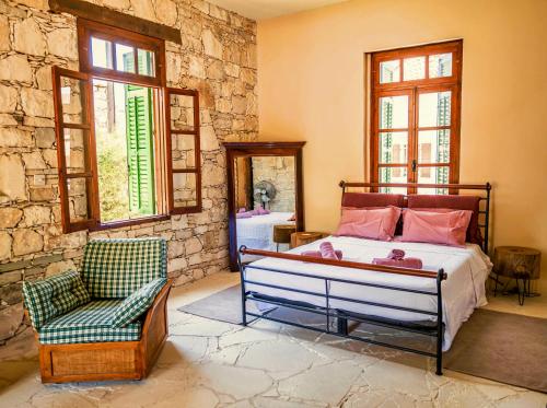 een slaapkamer met een bed, een stoel en een spiegel bij Listed Villa in Laneia in Lania