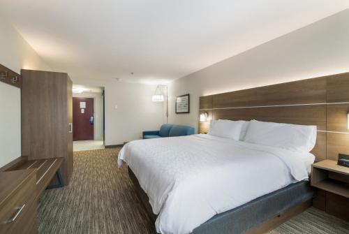 a hotel room with a large bed and a chair at Holiday Inn Express - Plymouth by IHG in Plymouth