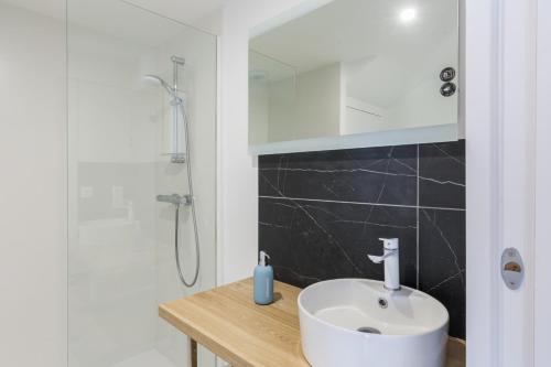La salle de bains est pourvue d'un lavabo blanc et d'une douche. dans l'établissement Kermaudez, à Pleubian