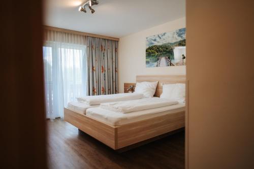 a bedroom with two beds and a window at Pension Pirkdorfer See in Sankt Michael ob Bleiburg