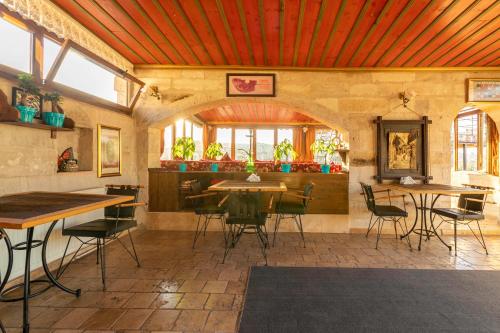 ギョレメにあるAdora Cave Suites -の部屋にテーブルと椅子があるレストラン
