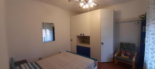 um pequeno quarto com uma cama e uma cadeira em DA PINA em Milão