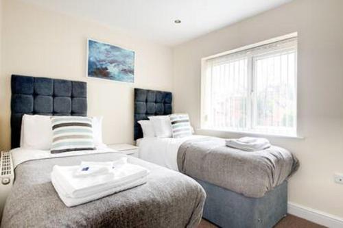 a bedroom with two beds and a window at Apartment 10 in Worksop