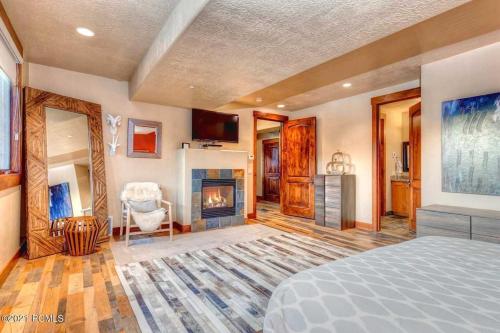 a bedroom with a bed and a fireplace at The Perch Park City - Magnificent 6 BR House With Views, Elevator, Game Room, Hot Tub in Park City