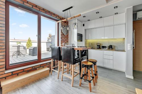 
a kitchen with a dining room table and a window at Dom & House - Apartments Waterlane Island in Gdańsk

