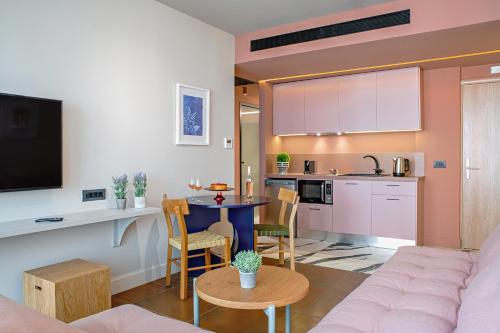 un soggiorno e una cucina con divano e tavolo di Pavo Art Hotel a Heraklion