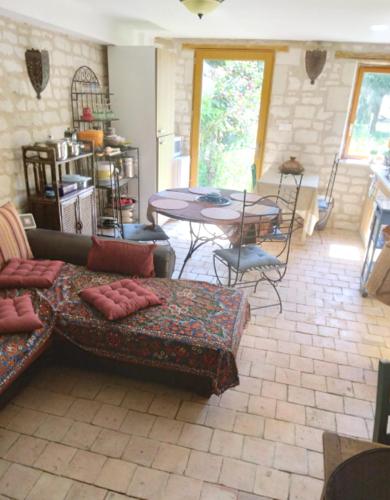 un salon avec un canapé et une table dans l'établissement Charmant refuge à Courchamps, terrasse et jardin, à Olivet