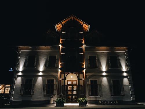 a large white building with lights on it at night at Hotel Starkl - Heritage & Unique in Bled