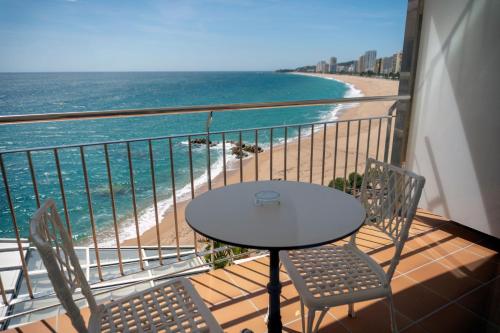 a table and chairs on a balcony with the beach at Hotel Costa Brava in Platja  d'Aro