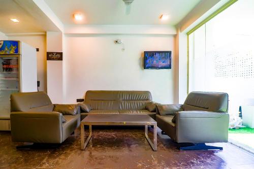 poczekalnia z dwoma skórzanymi kanapami i stolikiem kawowym w obiekcie FabHotel Kiara The Private Suites w mieście Gurgaon