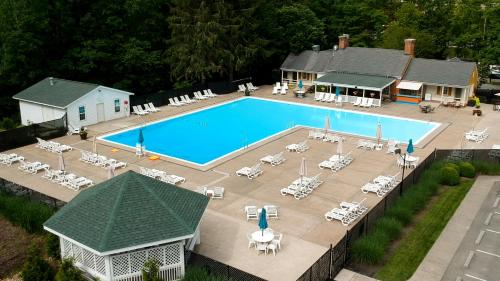 a beach with a pool, chairs, and a pool table at The Resort at Glade Springs in Daniels