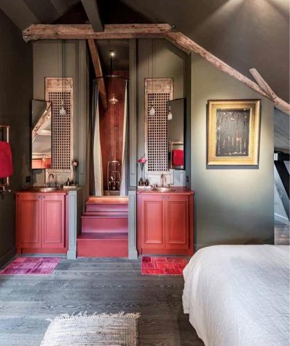 a bedroom with red cabinets and two sinks and a bed at Maison Fred Luxury Suites in Bruges