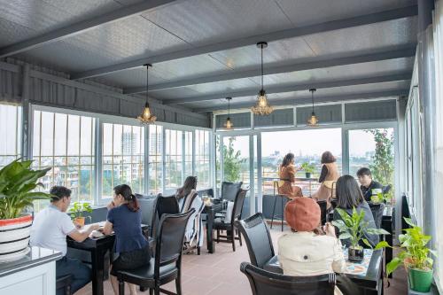 eine Gruppe von Personen, die in einem Restaurant an Tischen sitzen in der Unterkunft HOTEL TE AMO in Haiphong