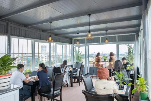 a group of people sitting at tables in a restaurant at HOTEL TE AMO in Hai Phong