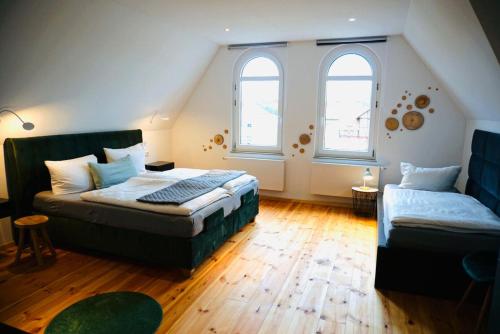 ein Schlafzimmer mit einem Bett und einem Sofa sowie zwei Fenstern in der Unterkunft FeWo26 in Thale