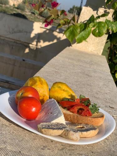 a plate of food with a sandwich and tomatoes on a table at Masseria Petra in Martano