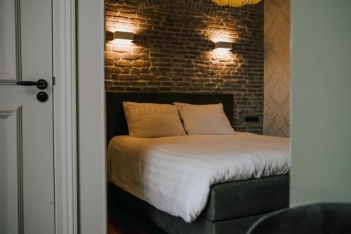 a bedroom with a bed with a brick wall at In de Brouwerij in Leeuwarden