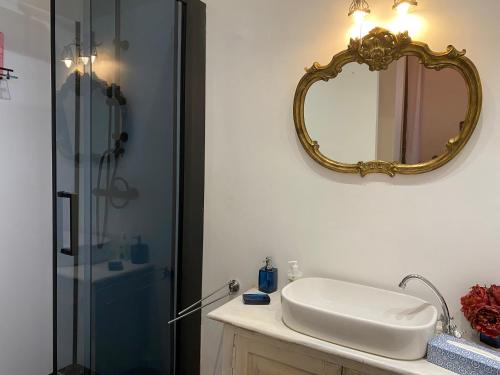 La salle de bains est pourvue d'un lavabo et d'un miroir mural. dans l'établissement The Pink Studio - Exceptional location IN city center - Unique & Elegant, à Namur