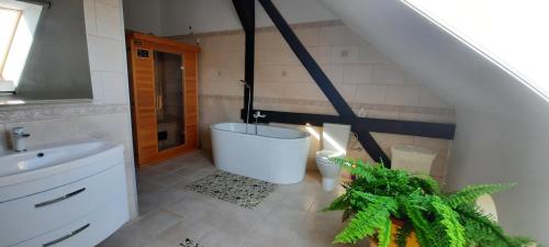uma casa de banho com uma banheira, um lavatório e um WC. em Dom wakacyjny-Czereśniowy Sad em Niemierze