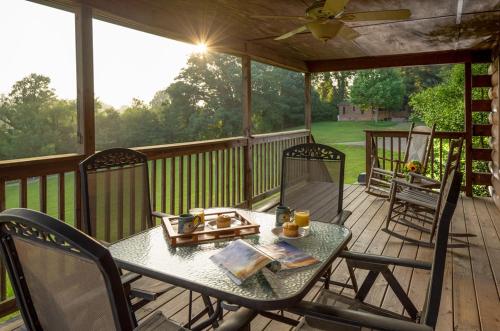 a patio with a table and chairs on a deck at Engadine Inn and Cabins in Candler