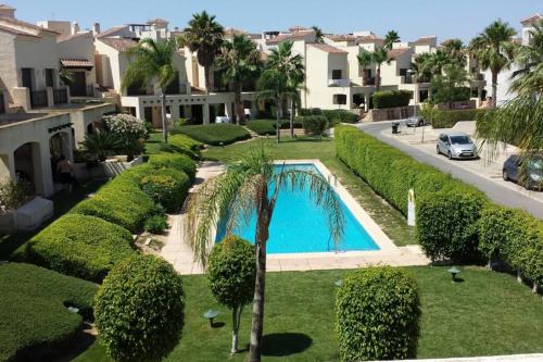 an overhead view of a yard with a swimming pool and trees at Roda Golf & Beach Resort. Townhouse, Poolside in Murcia