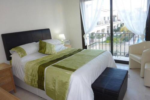 1 dormitorio con 1 cama grande y balcón en Roda Golf & Beach Resort. Townhouse, Poolside, en Murcia