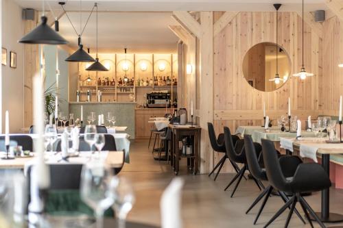 Altstadthotel Eibsen في أوترندورف: مطعم بجدران خشبية وطاولات وكراسي