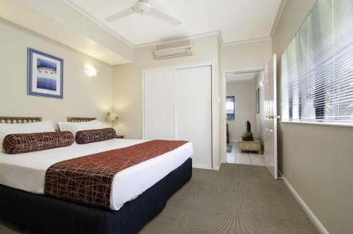 a bedroom with a bed and a window at Bay Villas Resort in Port Douglas